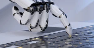 closed focus image of robot hand typing on laptop keyboard